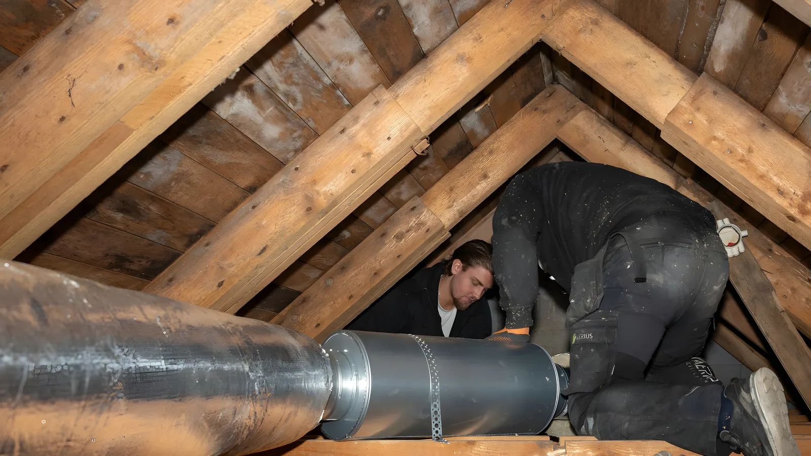 Två ventilationstekniker som monterar spirorör på en vind vid FTX-installation i Stockholm